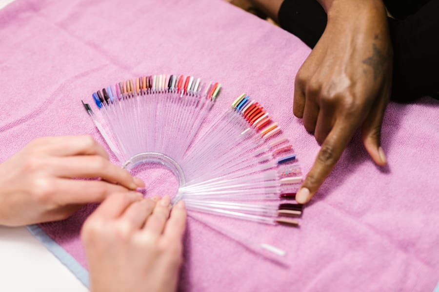 A nail technician working at a salon manicure station